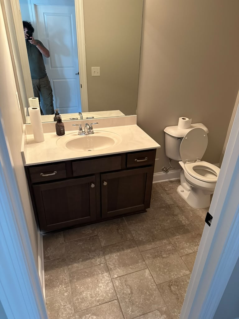 Hall bathroom before the remodel, with a dated espresso vanity and cultured marble top