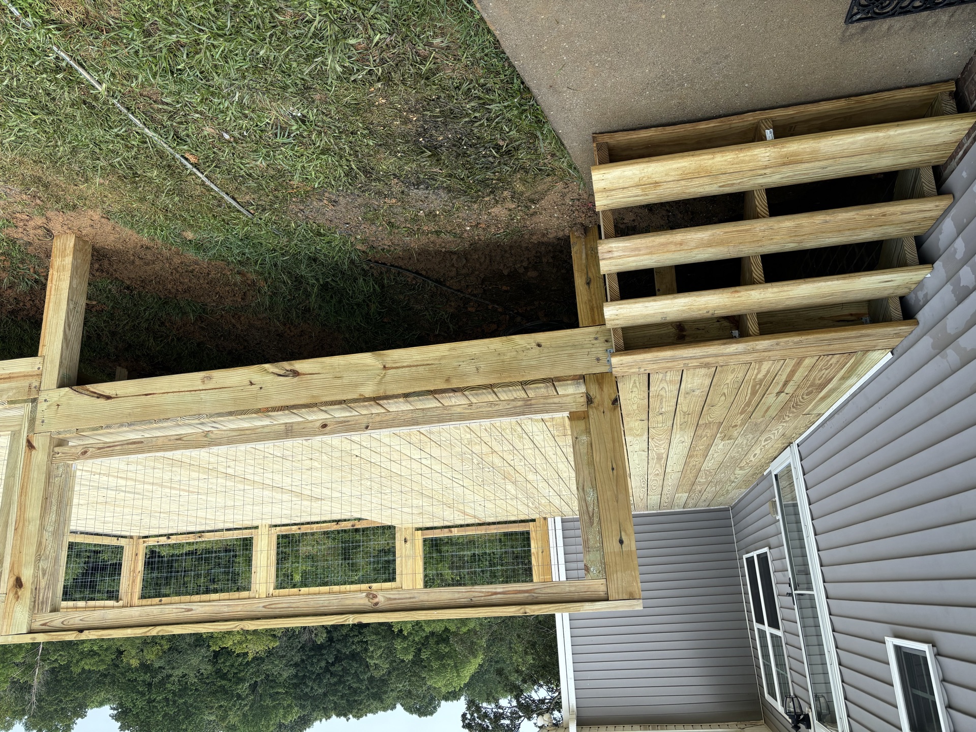 Deck joists and beam framing with wire-mesh railing panels