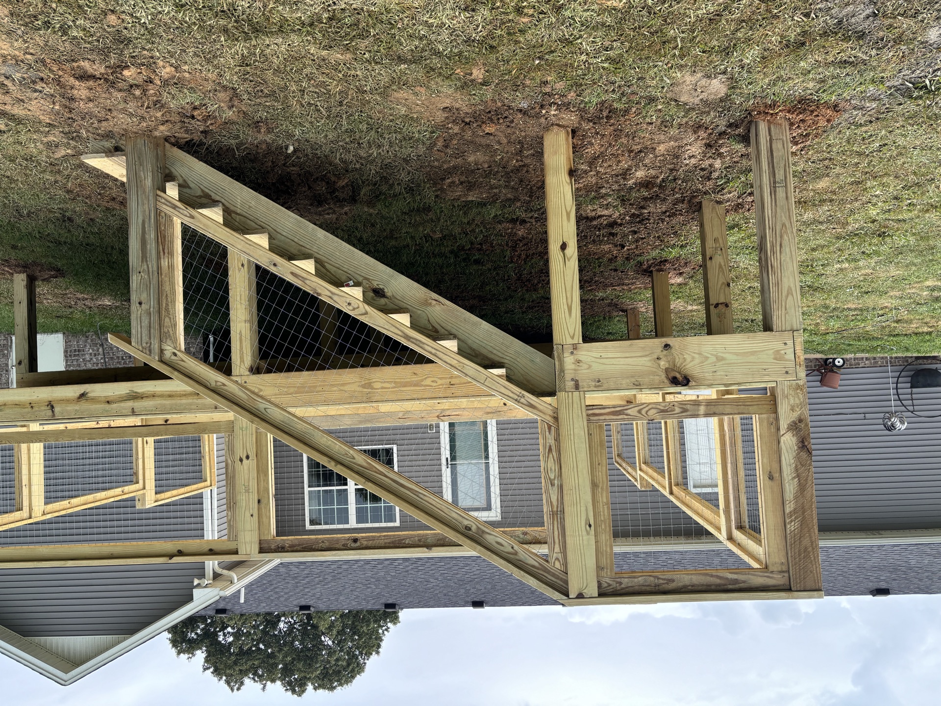 Deck framing with the stair stringer and wire-mesh railing in place