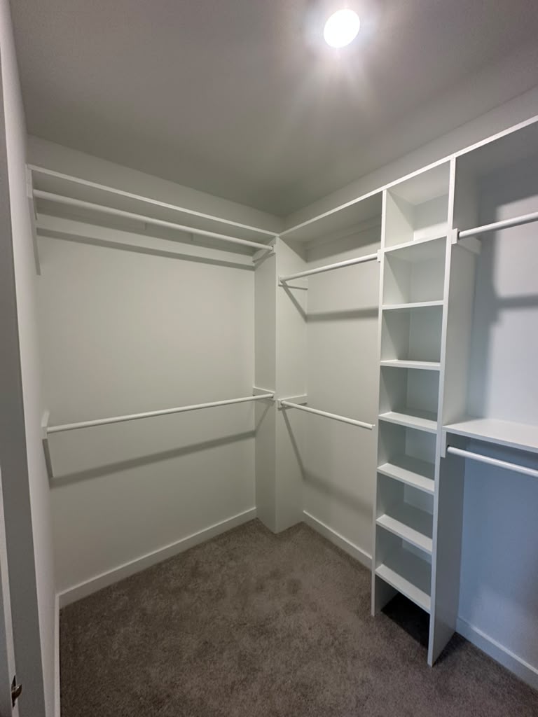 Walk-in closet with double hanging rods and a shelf tower